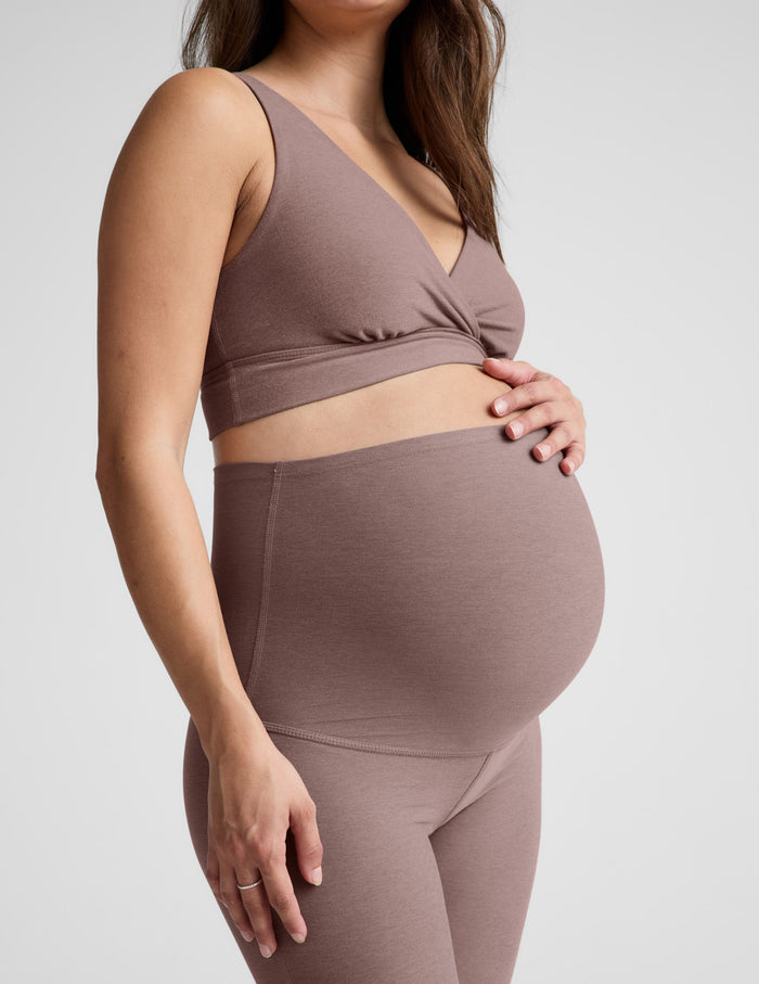 Side view of a pregnant woman wearing the blush Spacedye Practice Maternity Pant with the high waistband over her belly.
