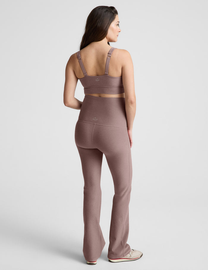 Rear view of blush Spacedye Practice Maternity Pant featuring a high waistband and flared bootcut hem on a model.