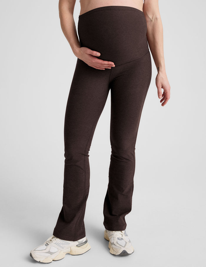 Woman wearing Brown Spacedye Practice Maternity Pant with high waistband, flare ankle and chunky cream sneakers.