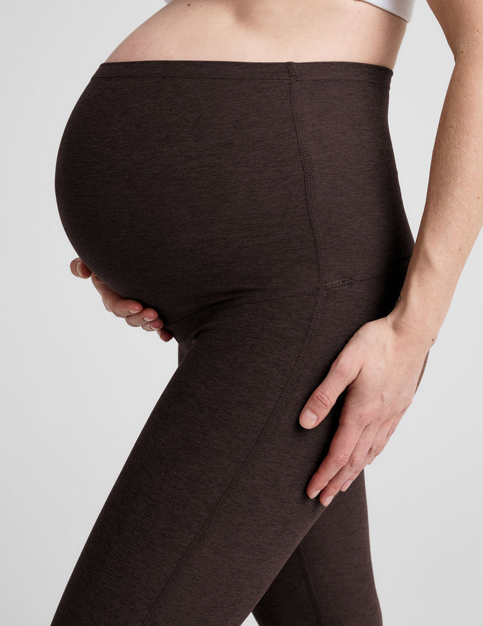 Side profile of woman wearing Brown Spacedye™ Practice Maternity Pant over bump with a white top and wide waistband.