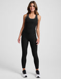 Woman wearing a black athletic outfit on a white background