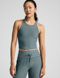 Woman wearing a green athletic outfit on a light gray background.
