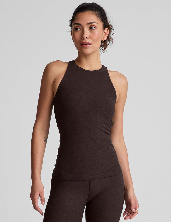 model wearing a brown high-neck racerback full length tank top against a plain background.