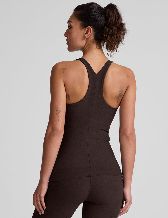 model wearing a brown high-neck racerback full length tank top against a plain background.