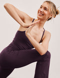 purple slim racerback cropped tank top and purple pants on a plain background.