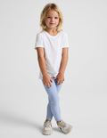 Girl wearing Blue Spacedye™ Toddler Legging with a white t-shirt and sneakers.
