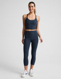 Woman wearing navy Spacedye™ Walk And Talk High Waisted Capri Legging with a matching tank top and white sneakers.