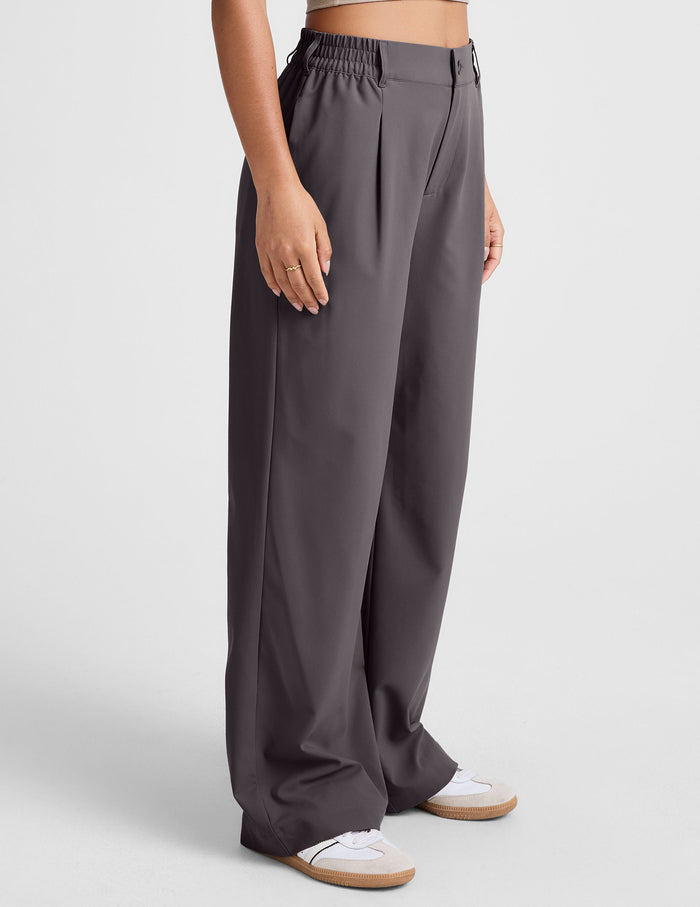 Status Wide Leg Trouser in charcoal grey. Side view of flowy, loose-fit pants with front pleats and elastic waistband.