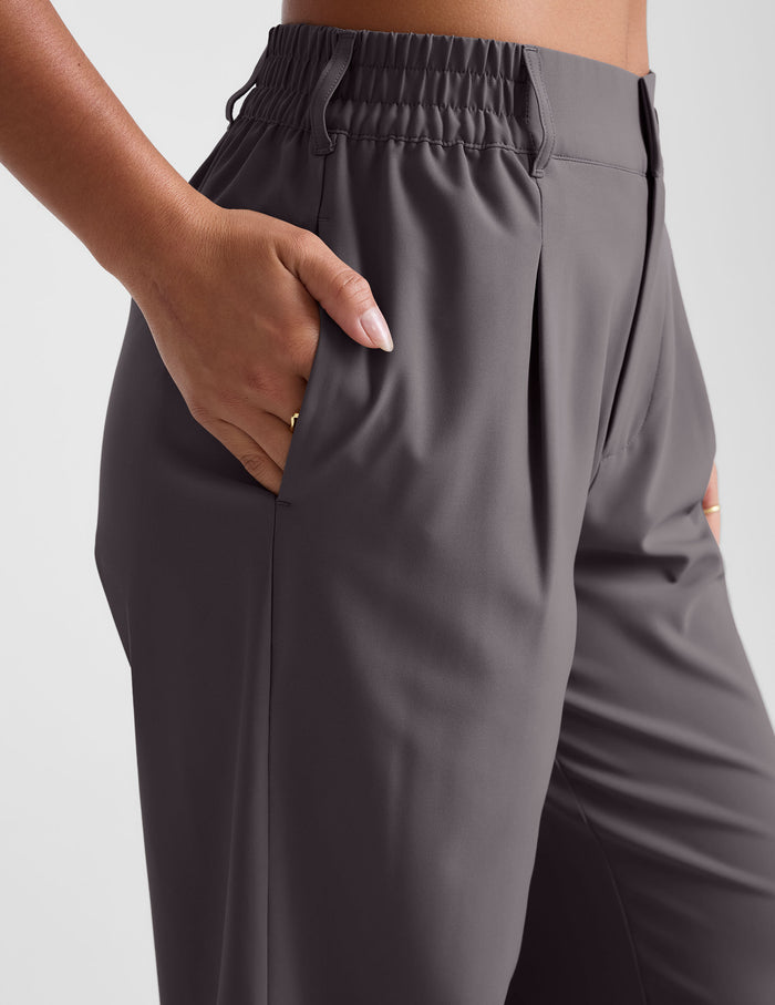 Status Wide Leg Trouser in charcoal featuring an elastic waistband, pleats, and a hand resting in the side seam pocket.