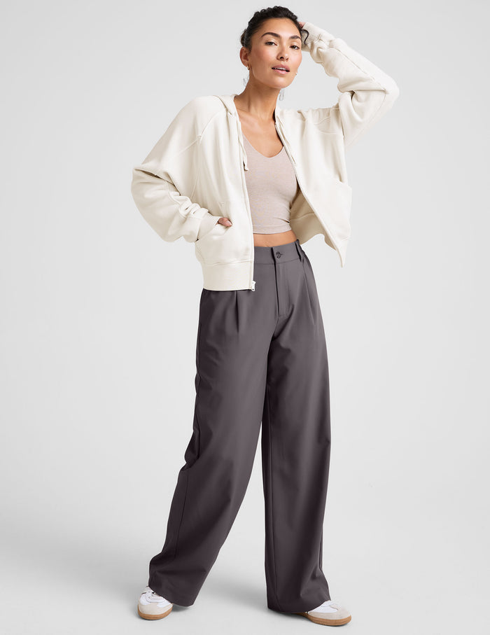 Dark grey Status Wide Leg Trouser with pleats and a loose fit, worn by a model with a cream hoodie and tan top.