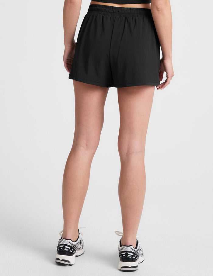 black shorts with a 2.5" inseam, encased elastic at waistband with drawcord​, self binding at hem edges​, side zipper pockets, and interior performance lining shorts​.