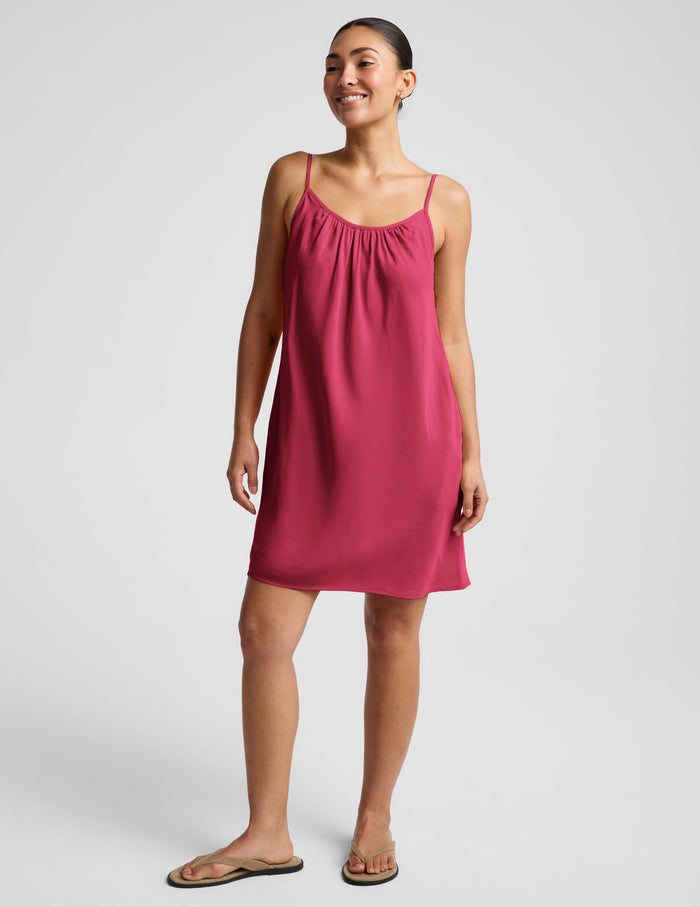 Woman wearing a red mini tank dress against a plain background.