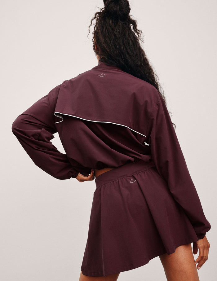red zip-up jacket with white piping and pockets.
