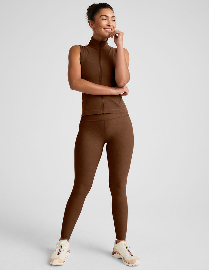 brown zip-up vest with a mesh upper back detail and pockets.
