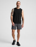 Man wearing Gray WarpLite™ Range Lined Short with a 6-inch inseam, paired with a black tank top and black sneakers.