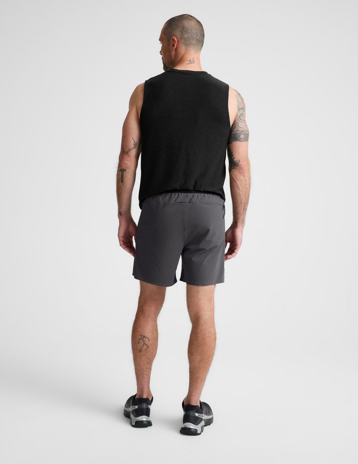 Man wearing Gray WarpLite Range Lined Short™ paired with a black tank top and sneakers, Rear view.